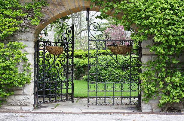 A partially open gate, entrance to a garden entrance to a garden